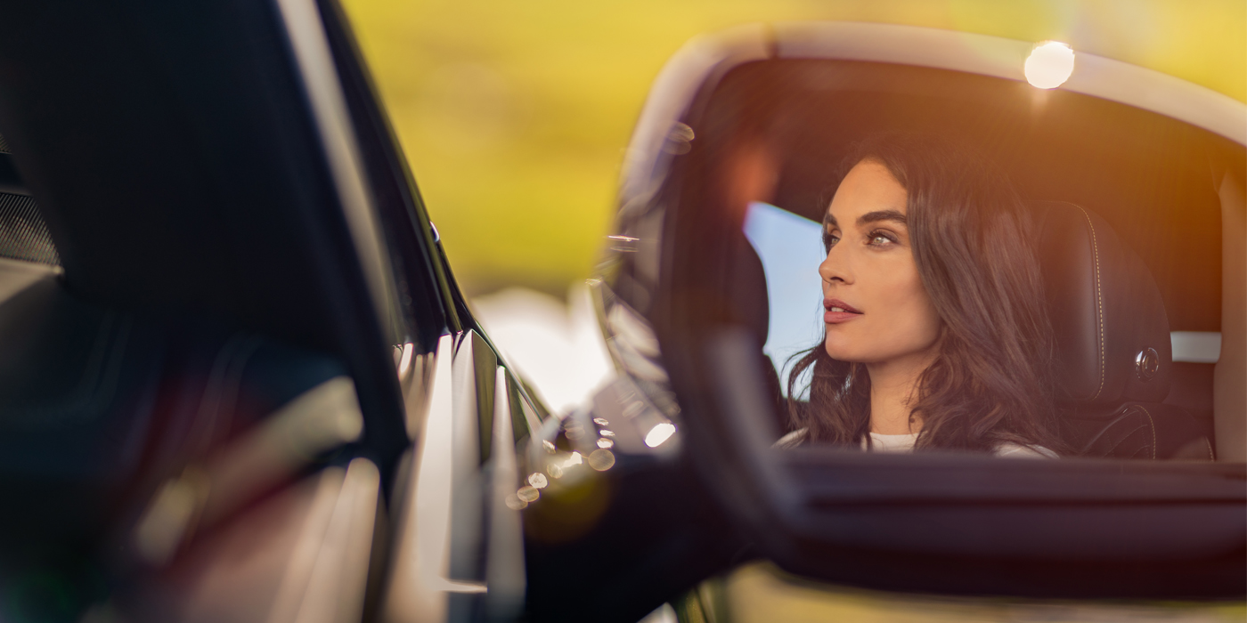 Gohm Sportwagen GmbH | Bentley Stuttgart profile of dark haired woman's face in mirror of Bentley car in sunlight