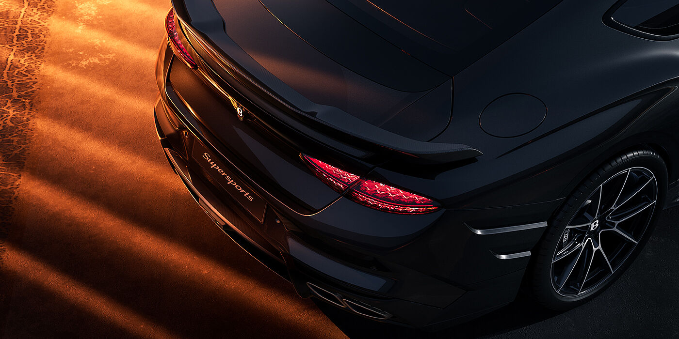 Gohm Sportwagen GmbH | Bentley Stuttgart Bentley Supersports rear overhead view showing illuminated rear lamps and Supersports Forged Alloy wheel in Anthracite paint against a dark grey and red background