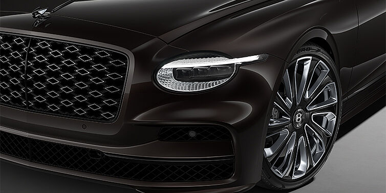 Gohm Sportwagen GmbH | Bentley Stuttgart New Bentley Flying Spur Mulliner sedan head lamp against Havana brown paint with  22" Mulliner Black Painted & Polished wheel