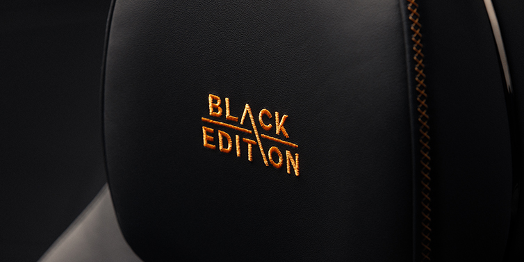 Gohm Sportwagen GmbH | Bentley Stuttgart Bentley Continental GT coupe seat headrest Black Edition stitched emblem in Mandarin colour against Beluga black hide